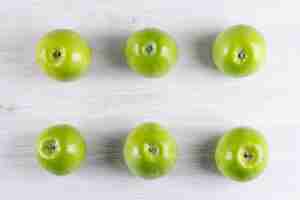Бесплатное фото Вид сверху зеленые яблоки на белой деревянной горизонтали