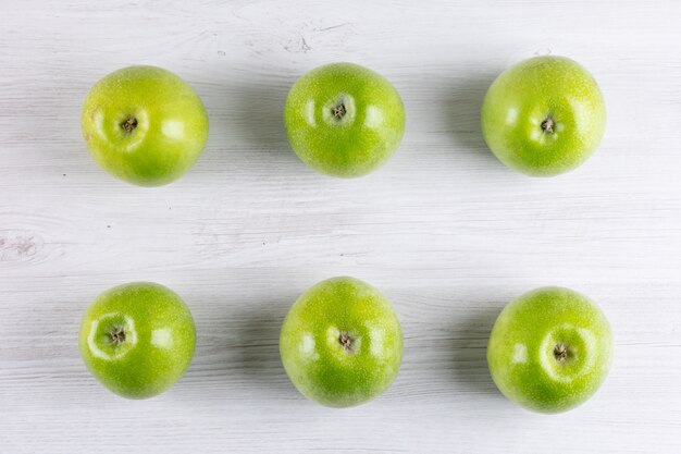 Free photo top view green apples on white wooden  horizontal