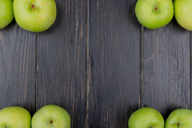 Top view  of green apples on wooden background with copy space