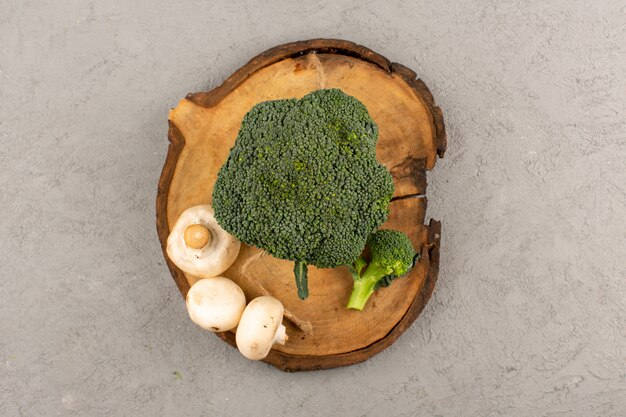 top view green broccoli along with mushrooms on the grey floor