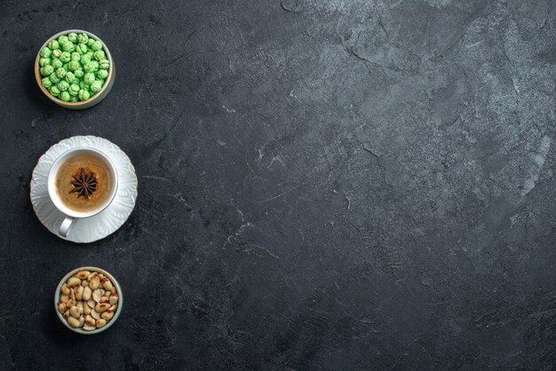 Top view green candies wih cup of coffee and nuts on the grey background biscuit sugar cake sweet cookie