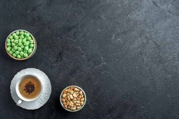 Top view green candies with cup of coffee and nuts on grey background biscuit sugar cake sweet cookie