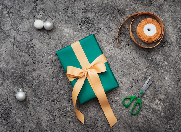 Top view of green christmas gift on marble background