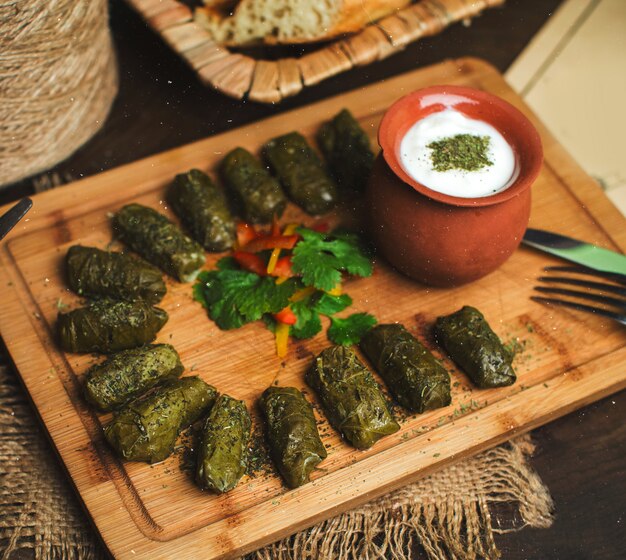 A top view green dolma along with yoghurt on the brow desk