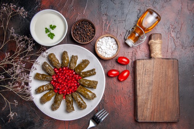 Top view of green leaf dolma with pomegranates on dark surface