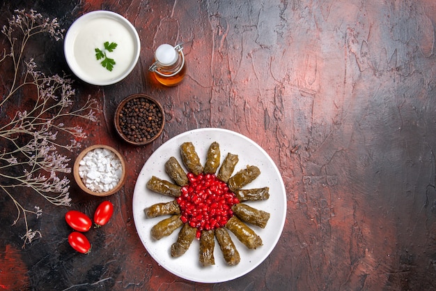 Foto gratuita vista dall'alto del dolma a foglia verde con melograni sulla superficie scura