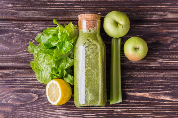 Top view green smoothie bottle with ingredients