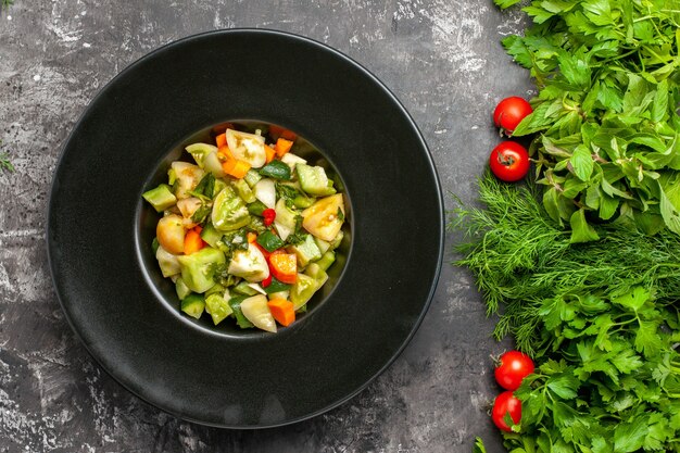 어두운 배경에 타원형 접시 녹색 토마토에 상위 뷰 녹색 토마토 샐러드