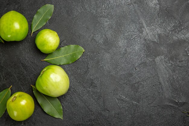Free photo top view green tomatoes and bay leaves on dark surface