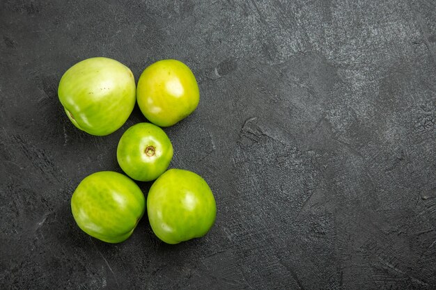 Top view green tomatoes on dark surface