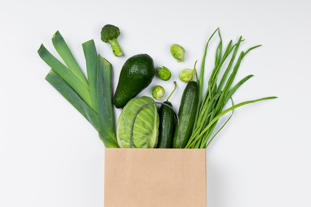 Top view green vegetables in paper bag