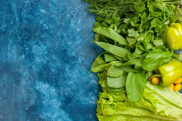 Free photo top view green vegetables parsley dill peppers lettuce cumcuat on blue background