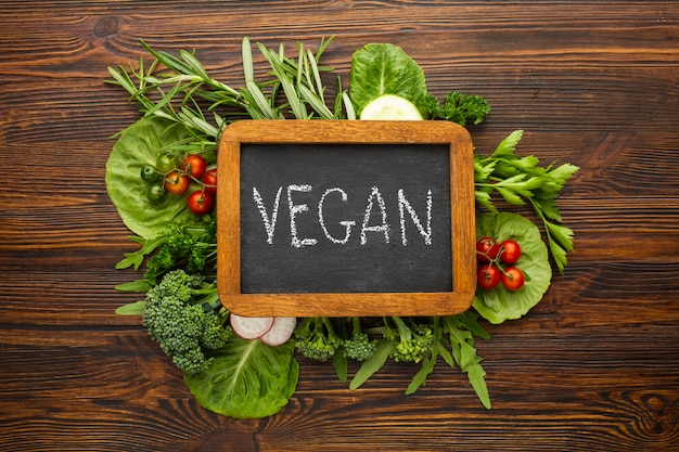 Top view green veggies with vegan lettering on chalkboard