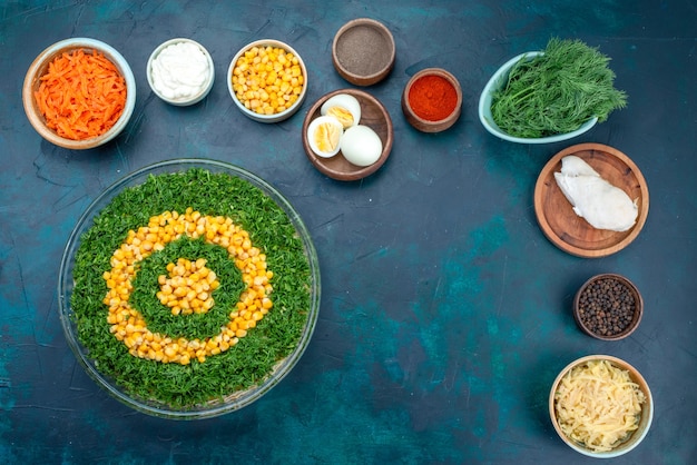 Free photo top view greens salad with corns along with sliced carrots and eggs on the dark-blue desk.