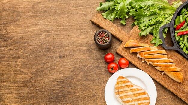 Top view grilled chicken and tomatoes with copy-space