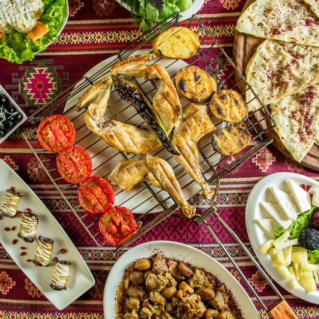 Top view of grilled chicken with vegetables on a colorful rug