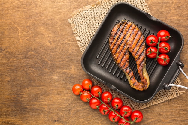 Top view grilled fish with tomatoes