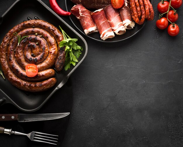 Top view grilled sausage with cutlery on the table