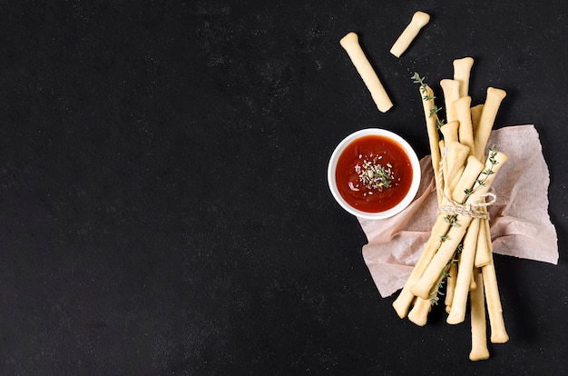 Foto gratuita vista dall'alto di grissini con ketchup e copia spazio