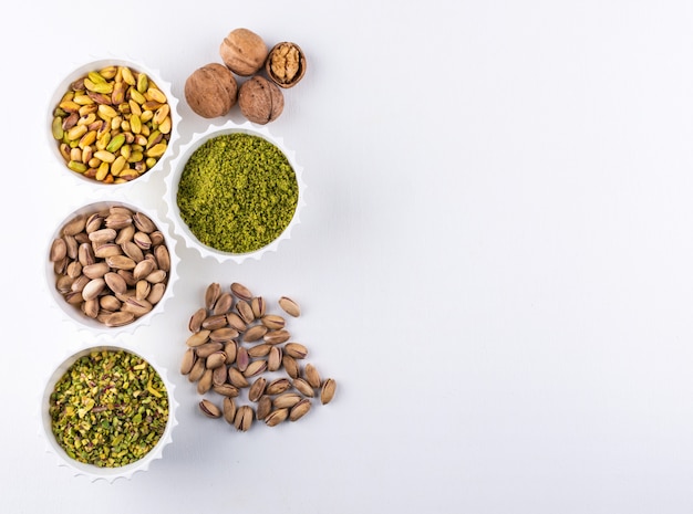 Top view ground, milled, crushed or granulated pistachios in a bowls on white