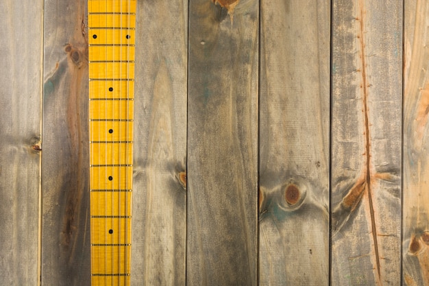 Top view of guitar strings and fret board on wooden background