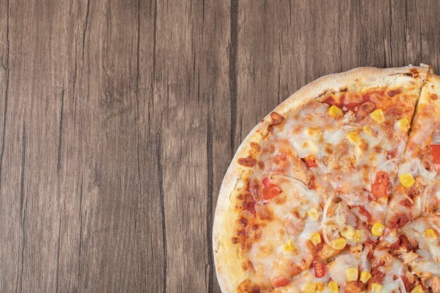 나무 접시에 모짜렐라 피자의 절반의 상위 뷰.