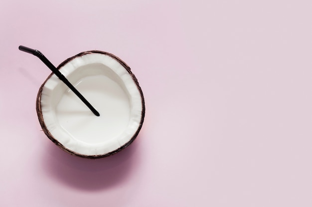 Top view halved coconut on pink background with copy space
