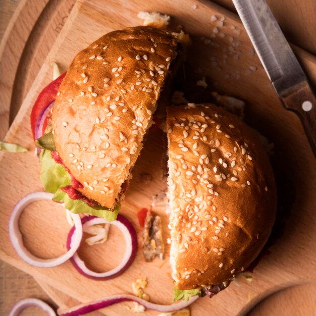 Top view halved hamburger on wooden board