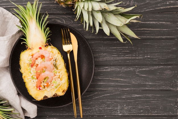 Top view halves of pineapple with cutlery