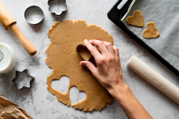 Top view hand cutting dough with shapes