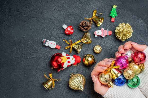 Top view of hand holding colorful decoration accessories on dark background