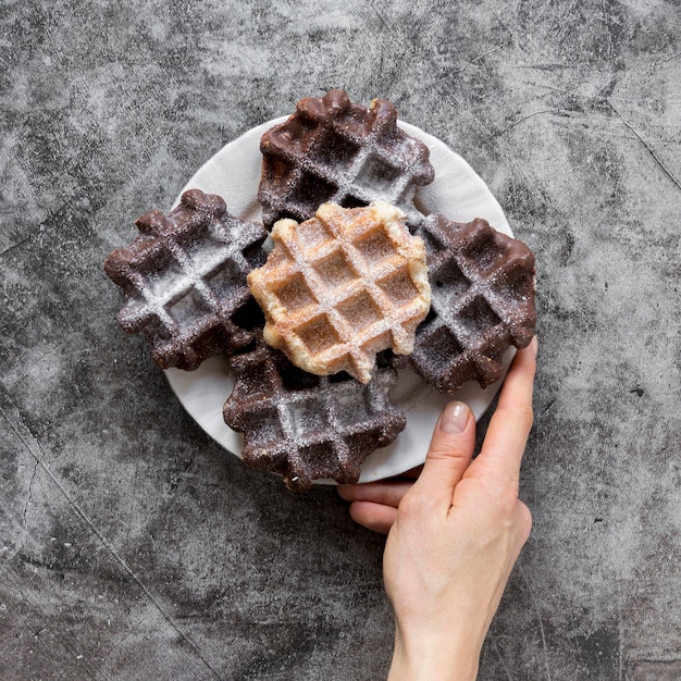 Top view of hand holding plate with waffles