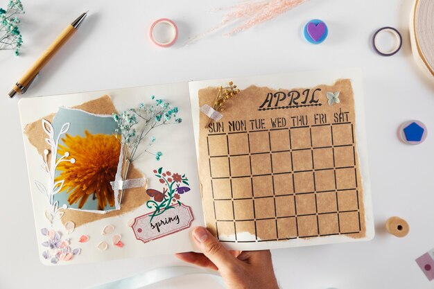 Top view hand holding scrapbook with flowers