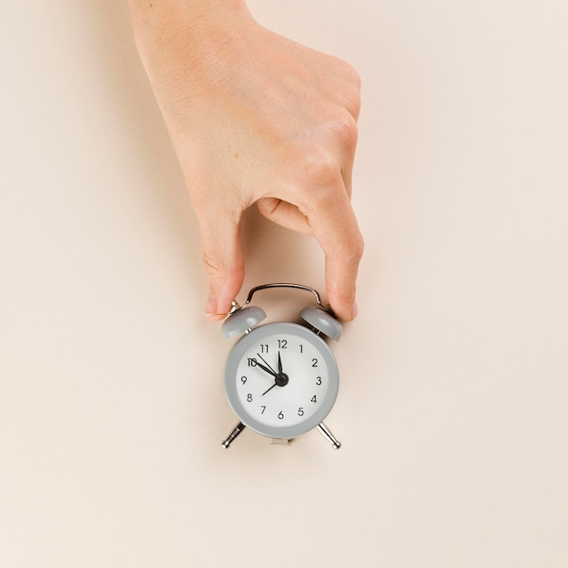 Top view of hand holding tiny clock