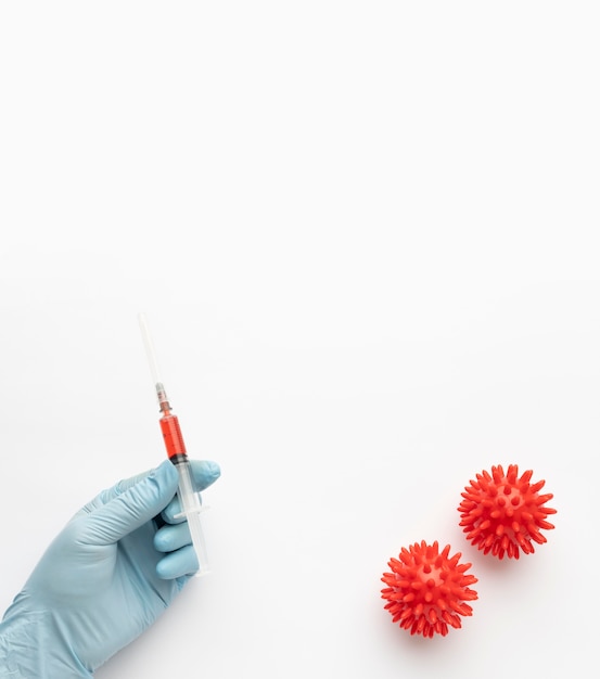 Free photo top view of hand holding vaccine with viruses and copy space