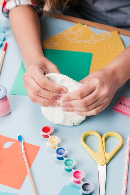 Top view of hand kneading white clay for making creative art