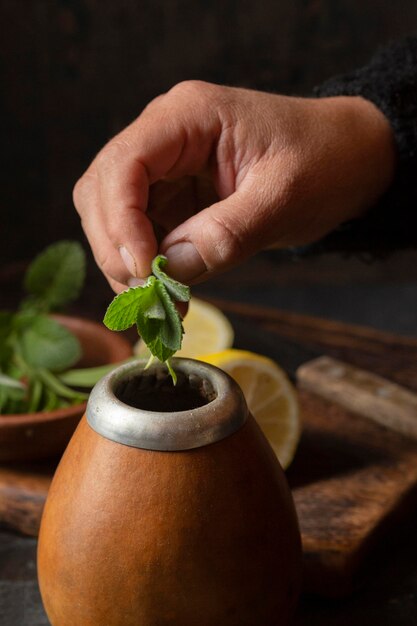 Top view hand putting mint leaves in mug