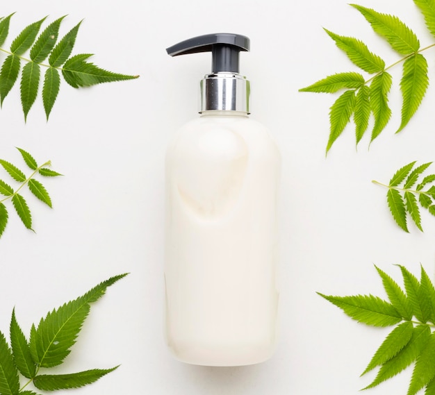 Free photo top view hand soap surrounded by leaves