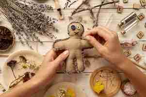 Free photo top view hand stings voodoo doll