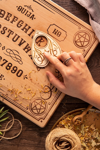 Free photo top view hand using ouija board tool