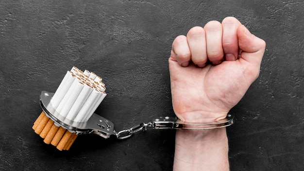 Top view hand with handcuffed cigarettes