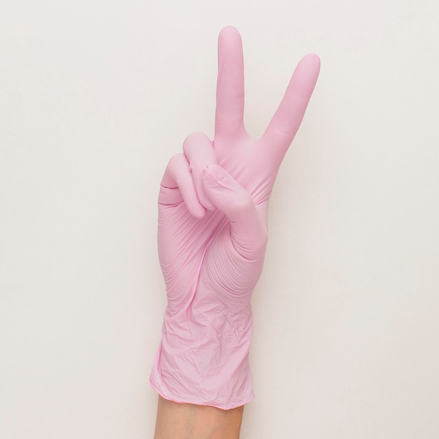 Top view of hand with surgical glove making peace sign