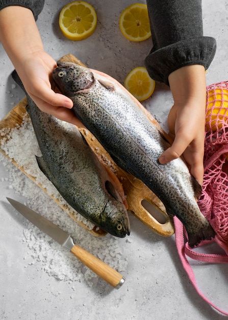 Top view hands cooking raw trout