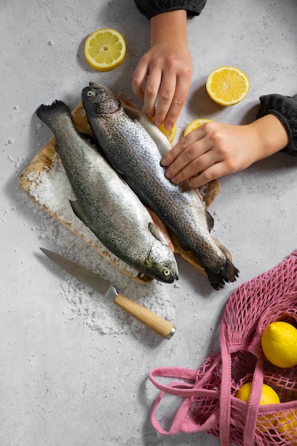 Free photo top view hands cooking raw trout