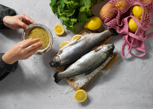 Top view hands cooking raw trout