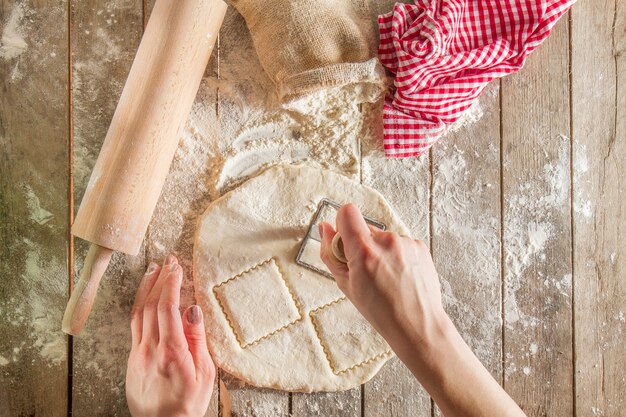 Top view of hands cutting the dough