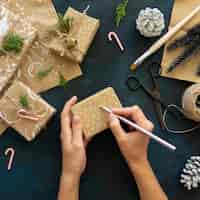 Free photo top view of hands decorating christmas gift