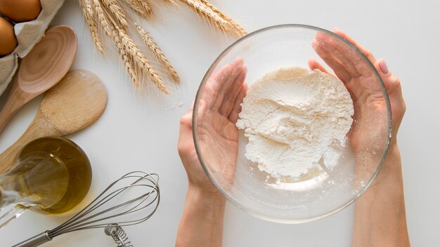 Top view hands holding bowl with flour