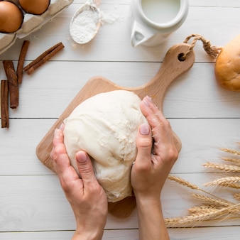 Top view hands holding bread dough