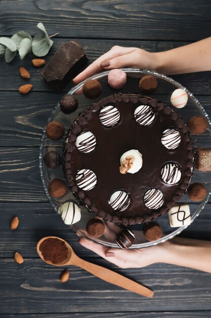 トップビューの手はチョコレートケーキを保持